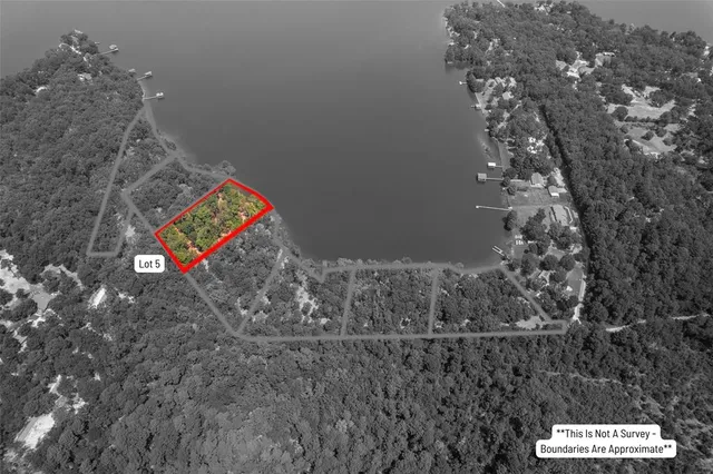 an aerial view of ocean and residential houses with outdoor space