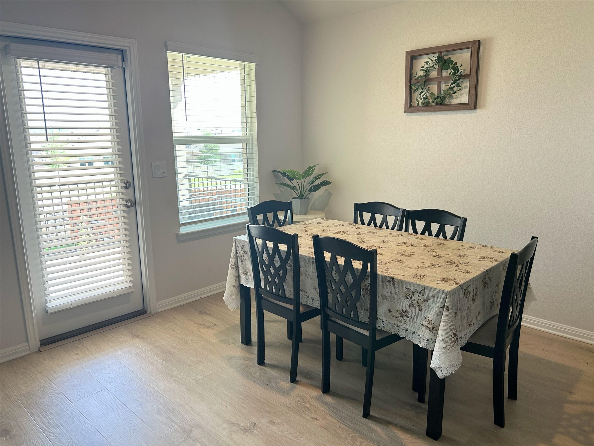 2412 Lightning View Leander, TX 78641 - Photo 7 of 24 A naturally illuminated dining area with light wood flooring and a convenient outdoor access door.