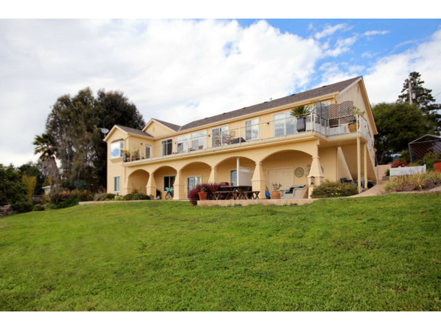 960 Smith Road Watsonville, CA 95076 - Photo 2 of 25 a view of a big house with a big yard and large trees
