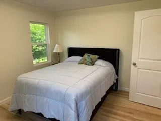 a large bed sitting in a bedroom next to a window