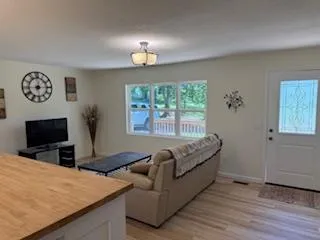a living room with furniture a flat screen tv and a large window