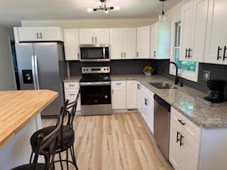 102 Ledford Chapel Road Hayesville, NC 28904 - Photo 3 of 30 a kitchen with stainless steel appliances granite countertop a stove a sink dishwasher a microwave oven with cabinets and wooden floor