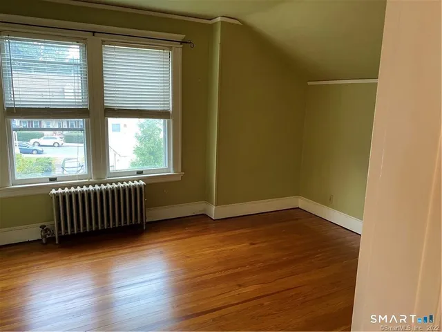 a living room with a bed furniture and a wooden floor