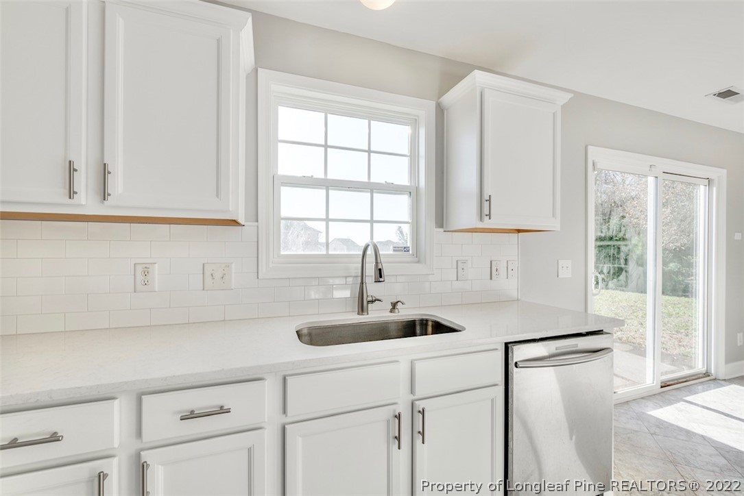 3104 Guiding Light Road Raleigh, NC 27610 - Photo 11 of 36 a kitchen with white cabinets and a sink