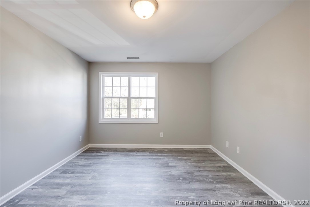 3104 Guiding Light Road Raleigh, NC 27610 - Photo 26 of 36 an empty room with wooden floor and windows