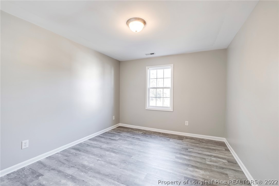 3104 Guiding Light Road Raleigh, NC 27610 - Photo 27 of 36 an empty room with wooden floor and windows