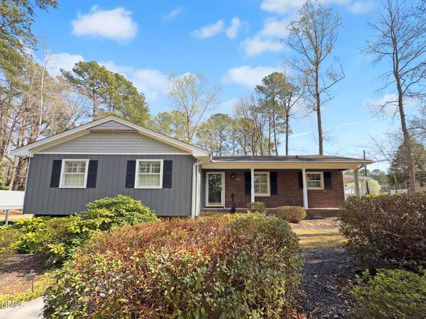 a front view of house with yard and trees around