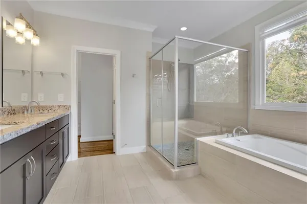 a spacious bathroom with a tub sink shower and mirror