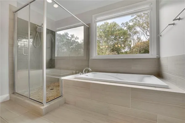 a spacious bathroom with a bathtub and shower