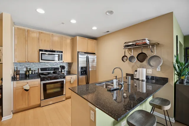 a kitchen with granite countertop a sink stainless steel appliances and cabinets