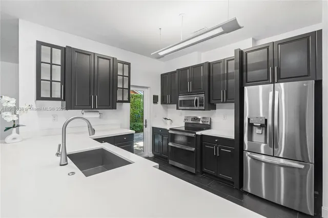 a kitchen with a sink stainless steel appliances cabinets and a counter space