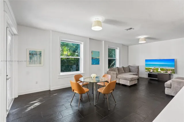 a view of a dining room with furniture a rug and wooden floor
