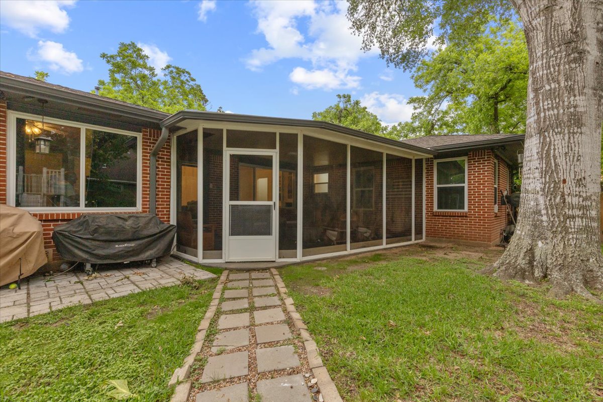 607 Short Street Smithville, TX 78957 - Photo 30 of 31 Red brick exterior featuring a screened-in porch with a white frame and entry door