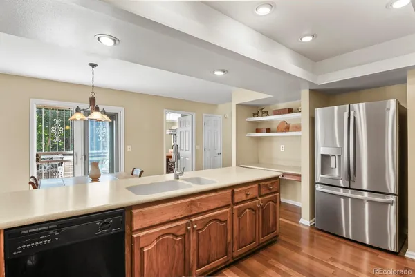 a kitchen with a refrigerator a sink and wooden floor