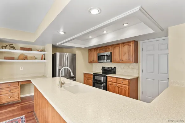 a large kitchen with stainless steel appliances granite countertop a sink and cabinets