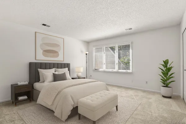 a bedroom with a bed and a potted plant