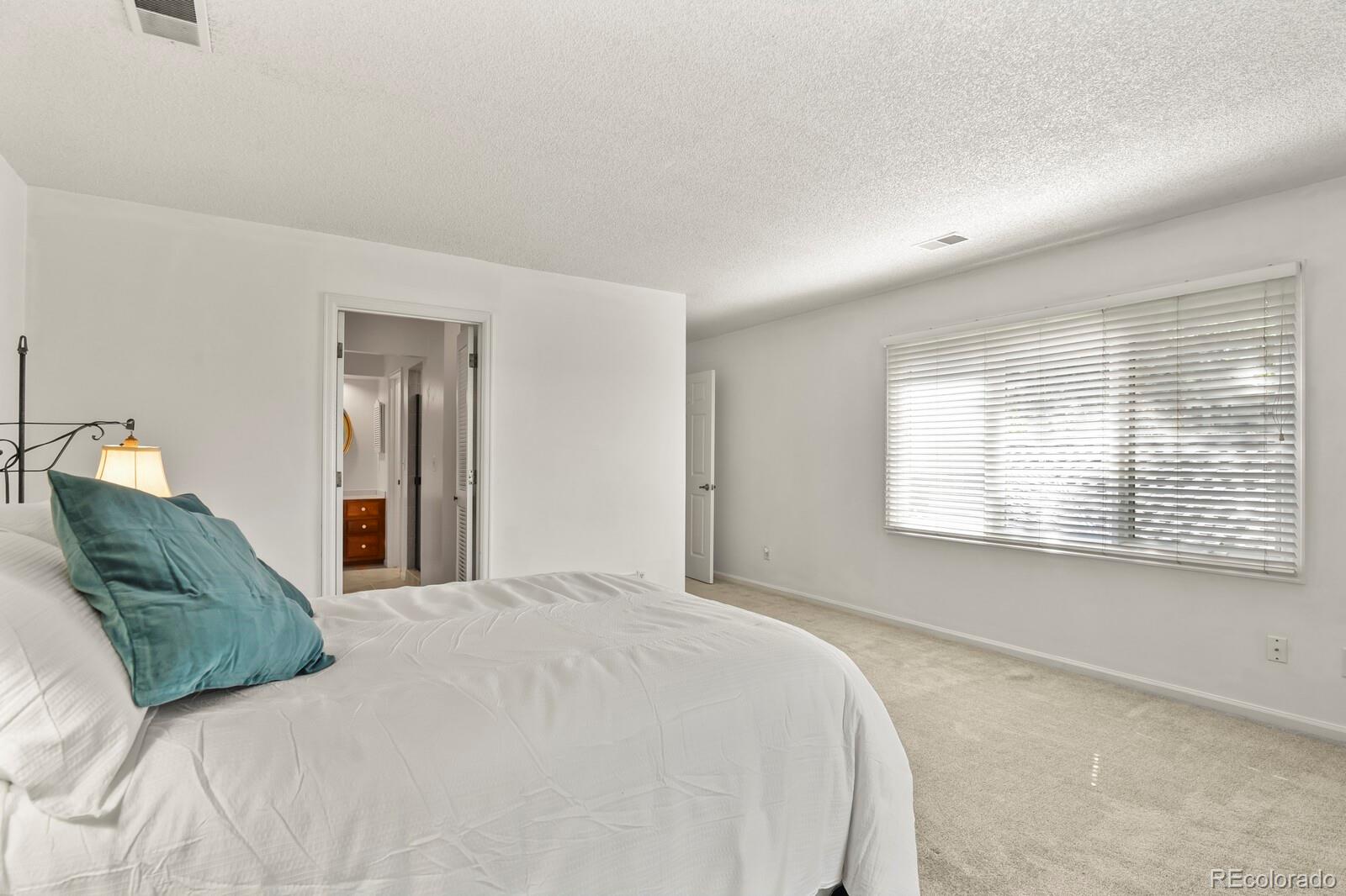 4530 South Verbena Street, Unit 309 Denver, CO 80237 - Photo 24 of 45 a bedroom with a bed and a large window