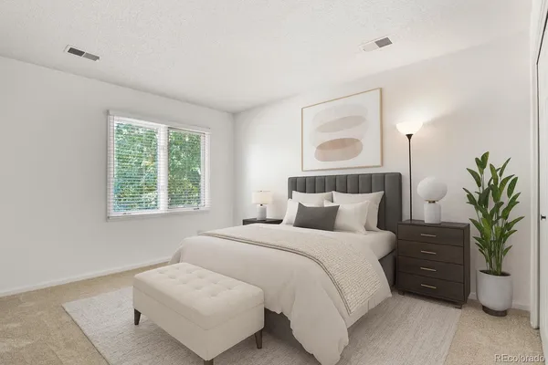 a bedroom with a bed and a potted plant