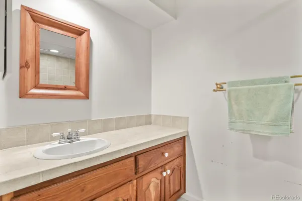 a bathroom with a granite countertop sink a mirror and a shower