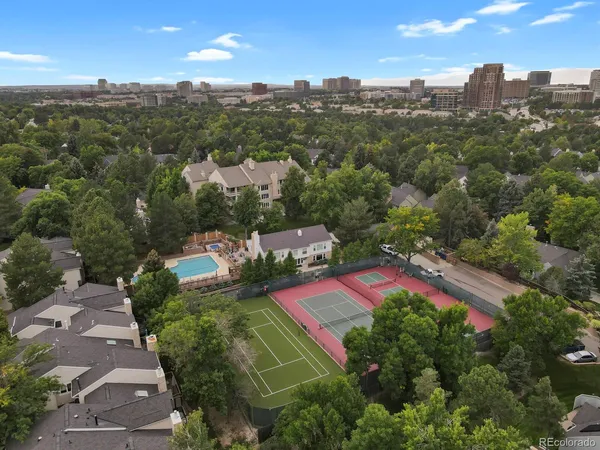 an aerial view of residential houses with outdoor space and trees