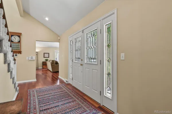 a view of a hallway with wooden floor and furniture