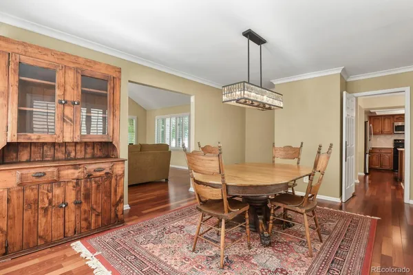 a dining room with furniture a chandelier and wooden floor