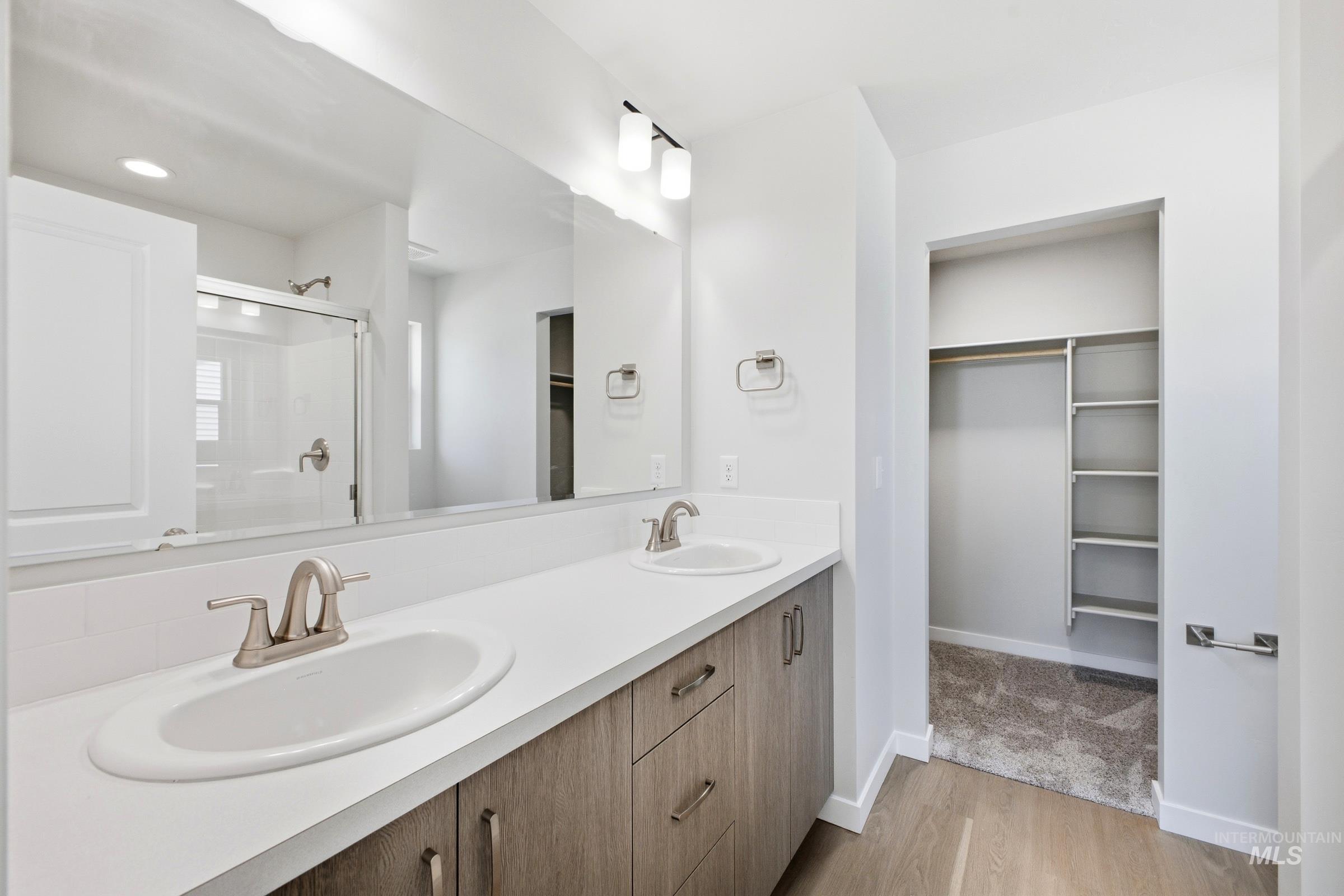 16434 Backfill Avenue Caldwell, ID 83607 - Photo 18 of 19 Dual vanity with undermount sinks, wood-finish cabinetry, and brushed nickel fixtures