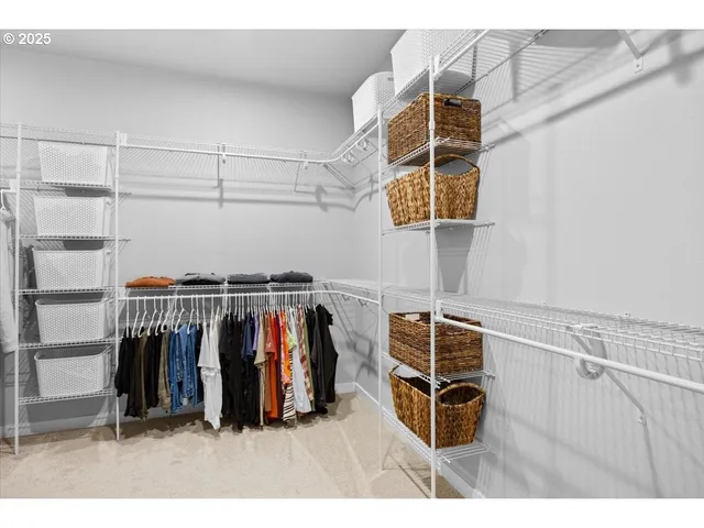 a view of walk in closet with clothes and shoes