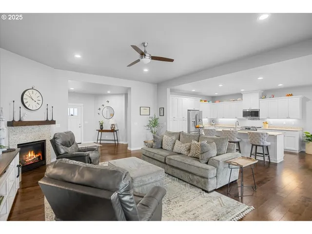 a living room with furniture kitchen view and a chandelier