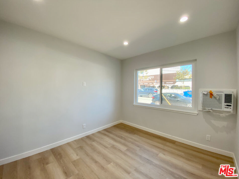11700 Dorothy Street, Unit 2 Los Angeles, CA 90049 - Photo 22 of 31 an empty room with wooden floor and windows