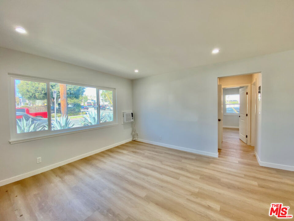 11700 Dorothy Street, Unit 2 Los Angeles, CA 90049 - Photo 24 of 31 an empty room with wooden floor and windows