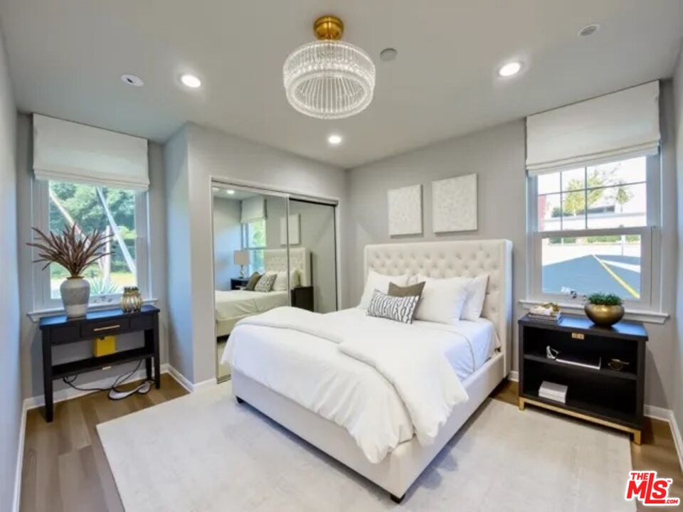 11700 Dorothy Street, Unit 2 Los Angeles, CA 90049 - Photo 6 of 31 a bedroom with a bed and a chandelier
