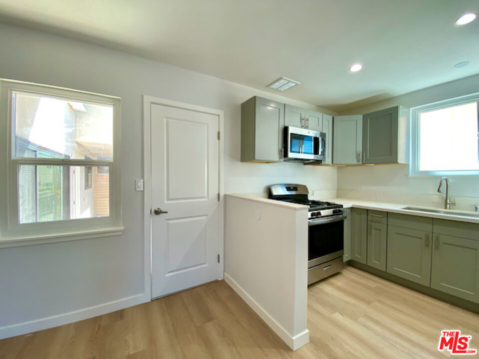 11700 Dorothy Street, Unit 2 Los Angeles, CA 90049 - Photo 10 of 31 a kitchen with a stove a sink and a microwave