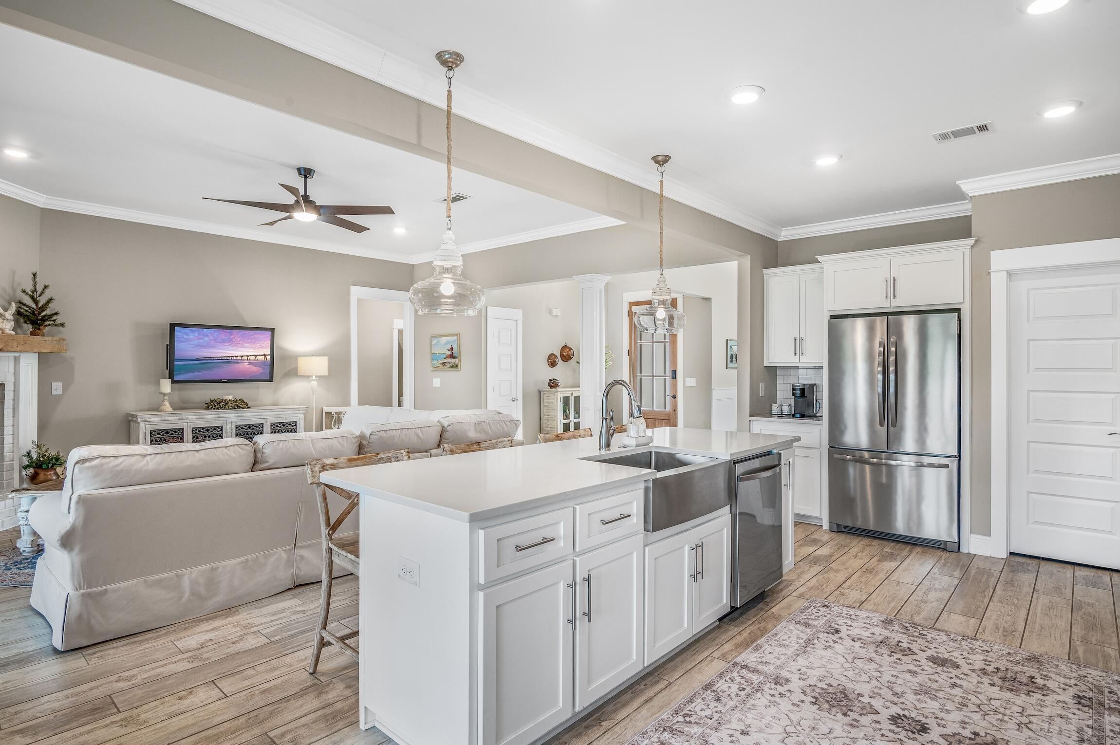 102 Mill Pond Cove Freeport, FL 32439 - Photo 12 of 46 a large white kitchen with a stove a sink dishwasher and a refrigerator with wooden floor