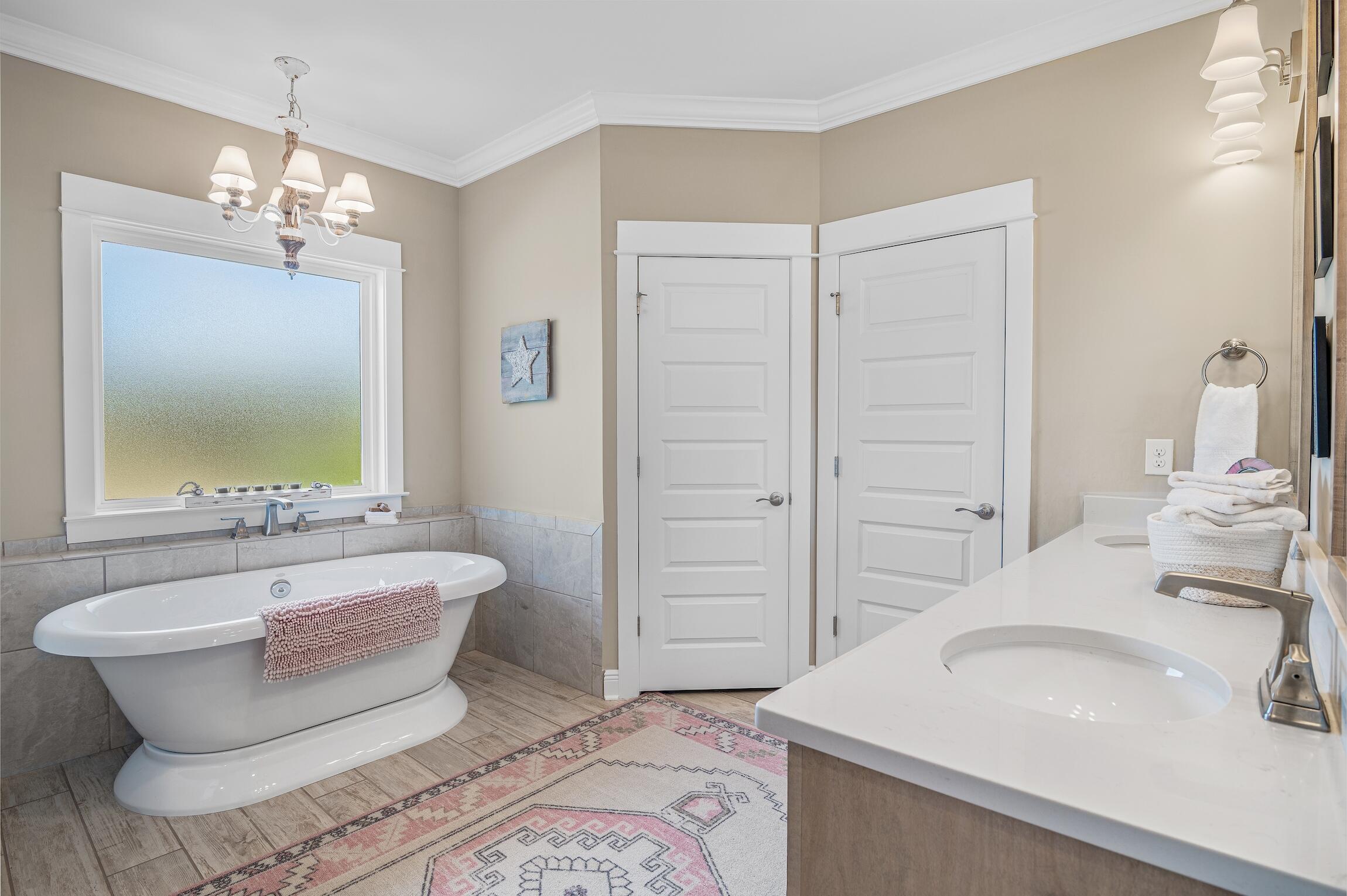 102 Mill Pond Cove Freeport, FL 32439 - Photo 21 of 46 a spacious bathroom with a double vanity sink a large mirror and a bathtub