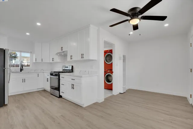 a kitchen with a white stove top oven and white cabinets