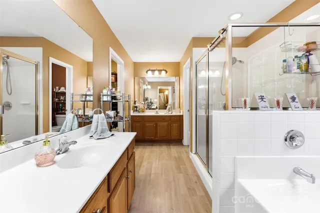 a en suite bathroom with a double vanity sink a mirror and shower