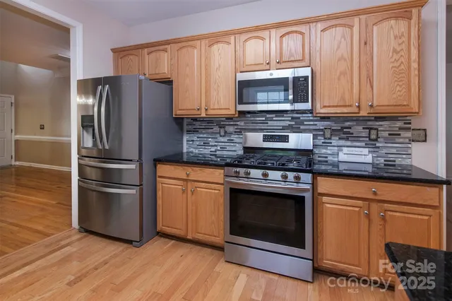 a kitchen with granite countertop a refrigerator stove and microwave