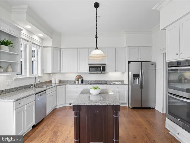 a kitchen with stainless steel appliances granite countertop a sink and wooden cabinets