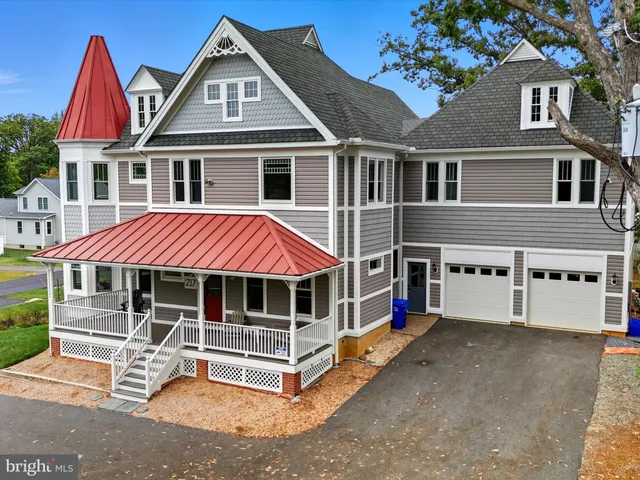 a view of a white house with large windows and a white table