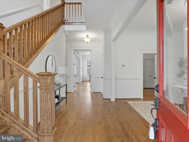 a kitchen with stainless steel appliances granite countertop a refrigerator a sink dishwasher a stove and white cabinets with wooden floor