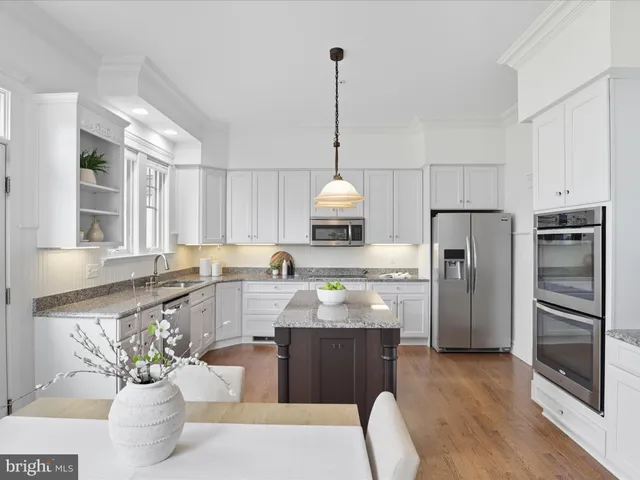 a living room with stainless steel appliances granite countertop furniture a couch and a window