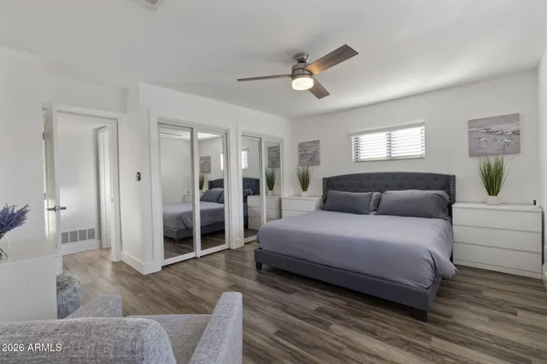 a spacious bedroom with a bed and a chandelier