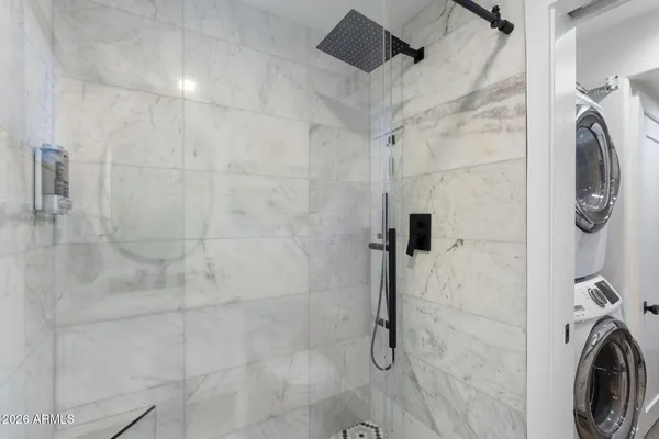 a bathroom with a washing machine and a shower