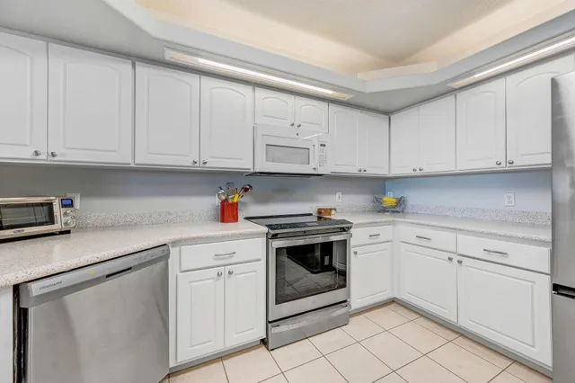 a spacious bedroom with a bed windows and wooden floor