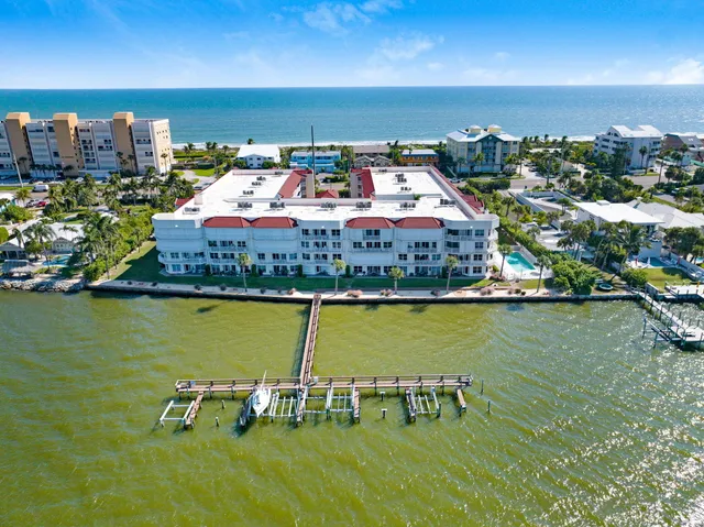 an aerial view of a building with outdoor space and ocean view