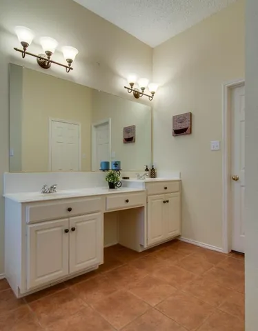 a spacious bathroom with a double vanity sink and a mirror