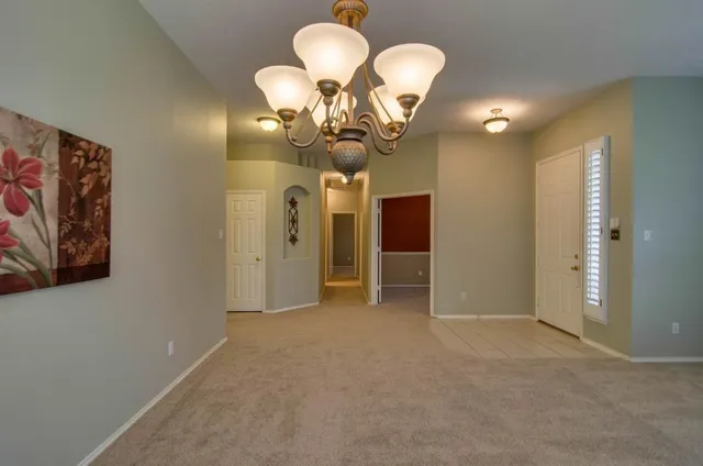 a view of a hallway with chandelier windows and couches