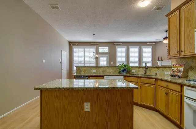 a kitchen with stainless steel appliances granite countertop a sink a stove counter space and cabinets