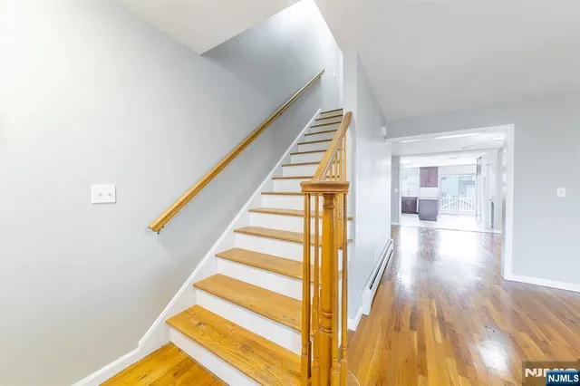 a view of a hallway with wooden floor and staircase
